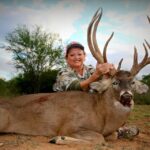 Female hunter with her massive whitetail buck