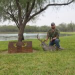 Hunter kneels with his big whitetail buck trophy