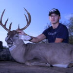 Boy poses with his whitetail buck kill