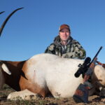 Hunter leans on his trophy Scimitar horned oryx with rifle